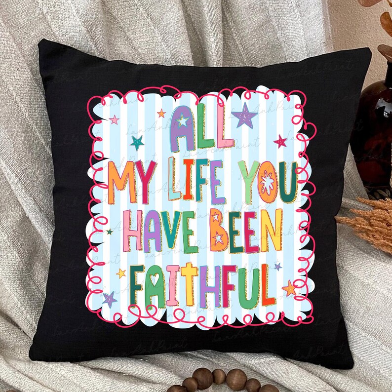 May include: Black square pillow with the text "ALL MY LIFE YOU HAVE BEEN FAITHFUL" in colorful letters. The text is set against a light blue and white striped background, framed by a pink, wavy border and stars.