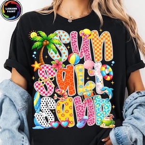May include: Black t-shirt with the words "Sun Salt Sand" in colorful, patterned letters. The design includes a palm tree, beach ball, seashell, and other summer-themed graphics.