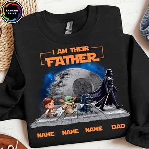May include: Black sweatshirt with the text "I AM THEIR FATHER" in orange. The design features cartoon characters, including Darth Vader, and the text "NAME NAME NAME DAD" at the bottom. A Death Star is in the background.
