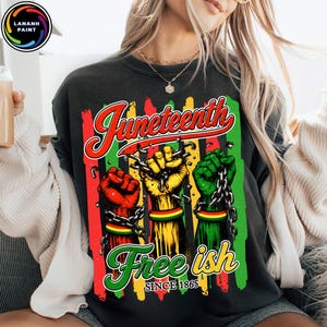 May include: Dark grey sweatshirt with a Juneteenth graphic. The design shows three fists in red, yellow, and green, each with a chain, and the words "Juneteenth" and "Free ish Since 1865" in a colourful font.