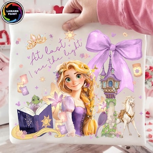 May include: A white pillowcase featuring a watercolor illustration of a princess with long blonde hair, a purple dress, and the text "At last I see the light." The design includes a castle, a horse, and a frog.