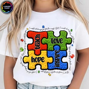 May include: White t-shirt with a colourful puzzle design. The puzzle pieces spell out "teach, love, hope, inspire." The shirt also has the text "I would not change you for the world. But I would change the world for you."