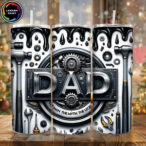 May include: A white tumbler with a black and silver design featuring tools, gears, and the word "DAD". The design includes the text "THE MAN, THE MYTH, THE LEGEND" and a black drip pattern at the top.
