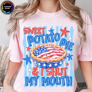 May include: Pink t-shirt with a graphic of a sweet potato pie decorated with the American flag, surrounded by stars and the text "Sweet Potato Pie & I Shut My Mouth."