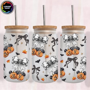 May include: Three glass tumblers with wooden lids and metal straws. Each tumbler features a Halloween-themed design with jack-o'-lanterns, bows, bats, and leaves. The tumblers are decorated with a spooky, yet elegant, design.