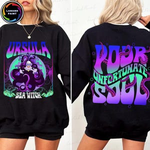 May include: Black sweatshirt featuring a colorful graphic of Ursula the Sea Witch with the text "URSULA SEA WITCH" on the front. The back of the sweatshirt has the text "POOR UNFORTUNATE SOUL" with tentacles.