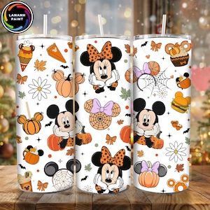 Op de afbeelding: Witte beker met een Halloween-ontwerp met Mickey en Minnie Mouse, pompoenen, vleermuizen en herfstbladeren. De beker bevat een rietje en is versierd met diverse Halloween-lekkernijen en accessoires.