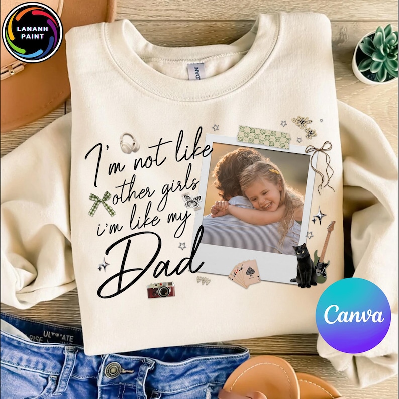 May include: Cream-colored sweatshirt with the text "I'm not like other girls, I'm like my Dad." A photo of a father and daughter is featured. Decorative elements include a black cat, guitar, and playing cards.