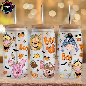 Puede incluir: Tres vasos de vidrio con tapas de madera y pajitas de metal. Cada vaso presenta un diseño de personaje diferente, incluyendo Winnie the Pooh, Piglet y Eeyore, con gráficos temáticos de Halloween y la palabra "Boo".