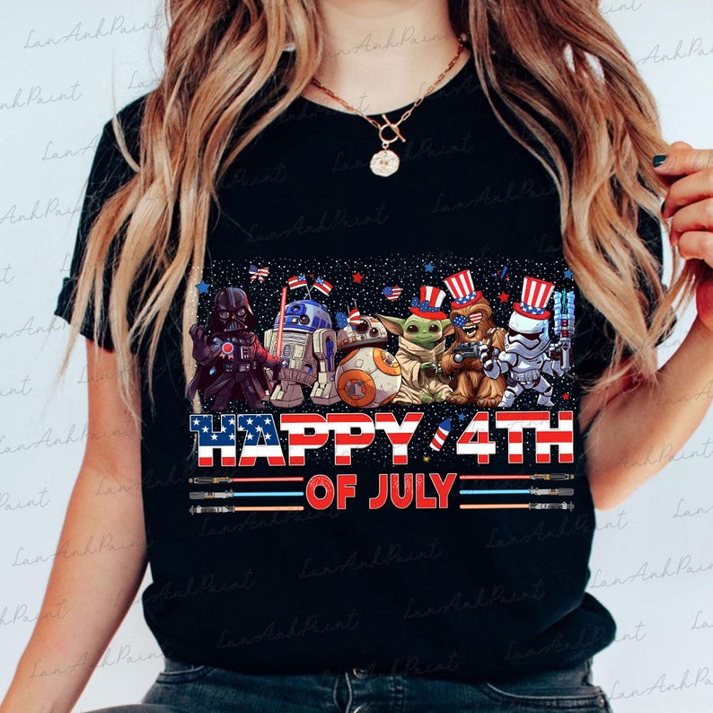 K&ouml;nnte beinhalten: Schwarzes T-Shirt mit einer Grafik von Star Wars-Charakteren in patriotischer Kleidung, darunter Darth Vader, R2-D2 und Baby Yoda, mit dem Text "HAPPY 4TH OF JULY" in Rot, Wei&szlig; und Blau.