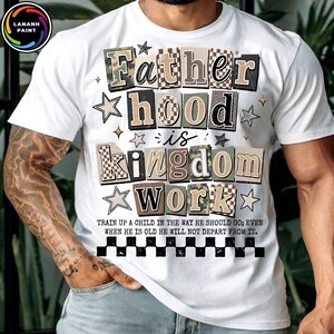May include: White t-shirt with the text "Fatherhood is Kingdom Work" in a block letter design. The text includes camouflage and checkered patterns, with star and diamond accents. The shirt also has a quote about raising children.