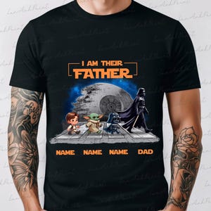 May include: Black t-shirt featuring a Star Wars design with the text "I AM THEIR FATHER." The graphic includes Darth Vader, a Death Star, and cartoon versions of characters. Below the characters are the words "NAME NAME NAME DAD."