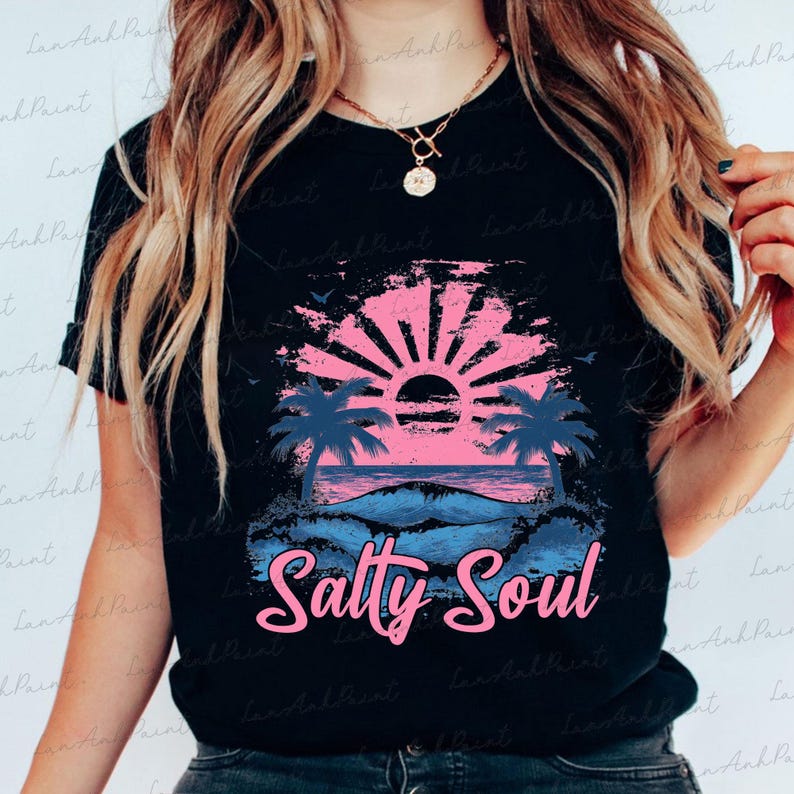 Pu&ograve; includere: Una maglietta nera con una grafica di tramonto rosa e blu e il testo "Salty Soul" in rosa.