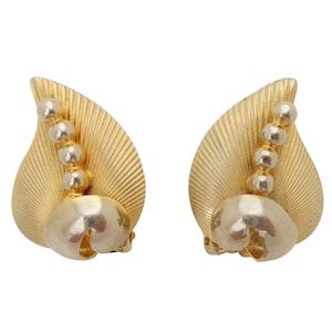 May include: A pair of gold tone clip-on earrings with a leaf design and a row of silver beads.