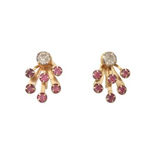 May include: A pair of gold-coloured earrings. Each earring has a central clear stone with six surrounding pink stones. The design is a stylized burst or spray, creating a delicate and elegant look. The earrings are set against a white background.