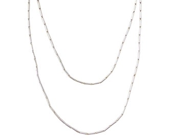 May include: A silver chain necklace with two strands of small, rectangular links.