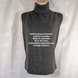 Könnte beinhalten: Ein ärmelloser grauer Rollkragenpullover mit weißen Zierstichen an den Seiten. Das Kleidungsstück enthält den Text: Belford gray turtleneck pullover sweater, Made in Australia, 36 to 40 inch bust, Cotton/Nylon/Spandex mix, Vintage Classic!