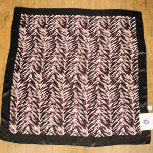 May include: A black and white patterned silk scarf with a purple and white zebra print. The scarf has a black border.