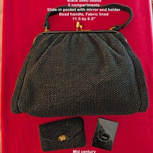 May include: A black, beaded, double-sided purse with a matching small wallet and a compact mirror. The purse has a bead handle and is fabric-lined. The purse measures 11.5 by 8.5 inches. The text on the image says "Mid century Made in USA."