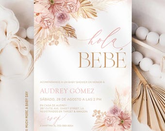 Può includere: Un invito rettangolare per baby shower con illustrazioni ad acquerello di foglie di palma essiccate e rose rosa polvere. Il testo recita "hola, BEBÉ", "ACOMPAÑANOS A UN BABY SHOWER EN HONOR A AUDREY GÓMEZ" e include i dettagli dell'evento, data, ora e luogo.