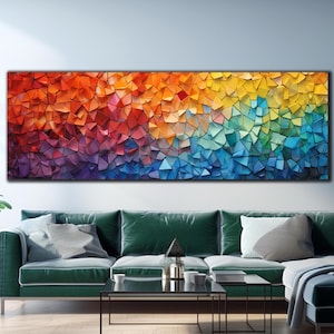 May include: Abstract art print featuring a colourful mosaic of geometric shapes in shades of red, orange, yellow, green, blue, and purple. The print is displayed on a wall above a green sofa and coffee table.