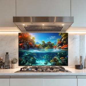 Puede incluir: Un vibrante protector contra salpicaduras de cocina con una escena de isla tropical. La obra de arte representa una vista dividida de una isla con exuberante vegetación, un edificio y una escena submarina con corales y peces. El cielo es azul.