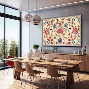 May include: A large, framed floral tapestry with a cream background and a vibrant display of pink, blue, and red flowers. The artwork hangs above a wooden sideboard in a dining room setting, with a long wooden table and chairs.