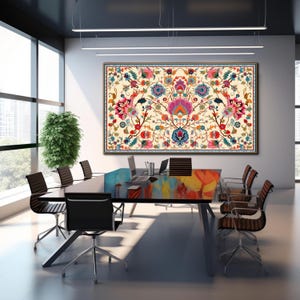 May include: A large framed floral tapestry with a cream background and a symmetrical design featuring pink, blue, red, and orange flowers. The tapestry hangs above a conference table with black chairs in a modern office setting.