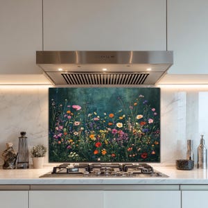 May include: A colorful floral print kitchen backsplash featuring a vibrant meadow of wildflowers in shades of pink, yellow, orange, and purple against a dark teal background. The image is installed above a gas stove and below a stainless steel range hood.