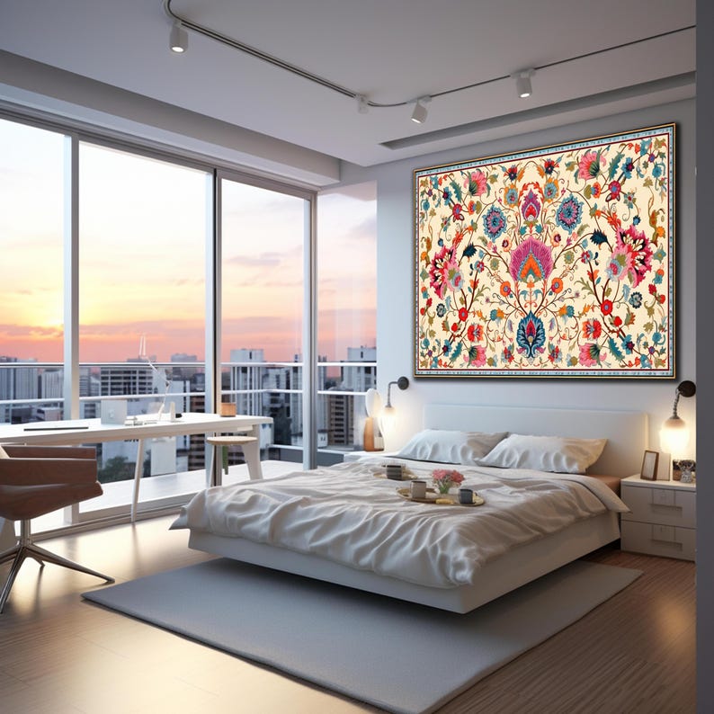 May include: A bedroom with a large floral tapestry above a bed. The tapestry features a cream background with a symmetrical design of colorful flowers in pink, blue, and orange. The room has a large window with a city view.