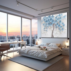 May include: A white bedroom with a large painting of a blue flower tree on the wall. The bed is white with white bedding and a tray on the bed with a cup and a plate. There is a window with a view of a city skyline.