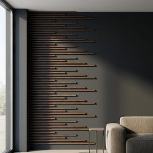 May include: A modern wall design featuring horizontal wooden slats against a dark gray wall. The slats are various lengths, creating a dynamic, textured pattern. A neutral-toned sofa and small side table are visible in the corner, suggesting a living room setting.
