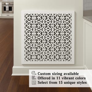 Op de afbeelding: Wit decoratief wandpaneel met een zwart sierlijk patroon. Het paneel is wit omlijst en aan een muur bevestigd. Tekst onderaan luidt: "Maatwerk beschikbaar", "Aangeboden in 11 levendige kleuren" en "Kies uit 15 unieke stijlen."