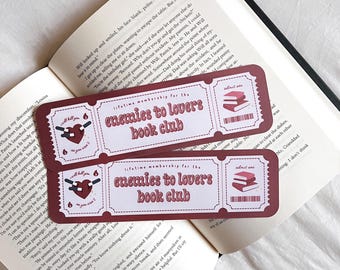 May include: Two red and white bookmark tickets with the text "Lifetime membership for the Enemies to Lovers Book Club". The tickets feature a heart with a knife through it and a stack of books.