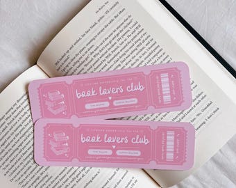 May include: Two pink bookmarks with the text "Lifetime Membership for the Book Lovers Club" and a stack of books illustration. The bookmarks are designed to look like tickets with a barcode and a "Certified Book Lover" stamp.