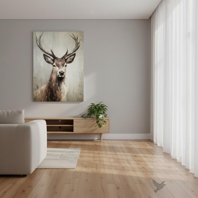 May include: A framed canvas art print featuring a detailed watercolor painting of a stag with large antlers. The artwork is in shades of brown and beige, mounted on a light gray background. The print hangs above a wooden cabinet in a modern living room.