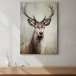 May include: A canvas print of a majestic deer with large antlers. The artwork features a detailed painting of the deer's head and upper body, with a neutral background. The color palette includes shades of brown, beige, and gray, creating a rustic aesthetic.
