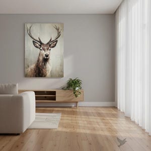 May include: A large rectangular canvas art print featuring a detailed portrait of a deer with large antlers. The deer is depicted in shades of brown and tan against a muted, textured background. The artwork hangs above a wooden media console in a modern living room.