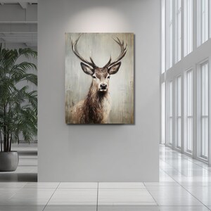 May include: A framed canvas art print featuring a detailed portrait of a deer with large antlers. The artwork uses a muted color palette of browns and grays, creating a rustic and natural aesthetic. The deer is centered, looking directly at the viewer.