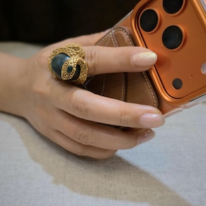 Serpentinite stone paired with antique gold plating for a dramatic contrast.