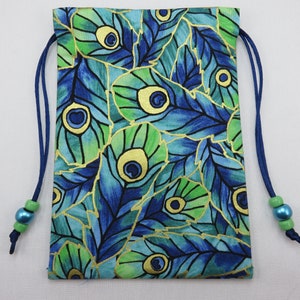 May include: A blue drawstring bag with a peacock feather pattern. The bag has gold accents and green beads on the drawstrings.