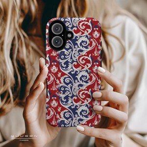 Op de afbeelding: Een telefoonhoesje in rood, wit en blauw met een bloemenpatroon. Het hoesje heeft een uitsparing voor de camera.