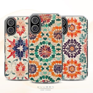 Op de afbeelding: Drie transparante telefoonhoesjes met een kleurrijk geometrisch patroon. Het patroon bestaat uit een mozaïek van kleine vierkanten in tinten oranje, rood, groen, blauw en paars. De hoesjes zijn ontworpen om te passen op een smartphone met een drievoudige camera lens.