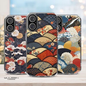 Op de afbeelding: Drie telefoonhoesjes met Japans geïnspireerde ontwerpen. De hoesjes tonen ingewikkelde patronen van golven, bloemen en geometrische vormen in marineblauw, rood, beige en goud. De merknaam "YUUGEN cases" is onderaan zichtbaar.