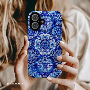 Op de afbeelding: Een blauwe en witte telefoonhoes met een bloemenpatroon. De hoes heeft een uitsparing voor de camera.