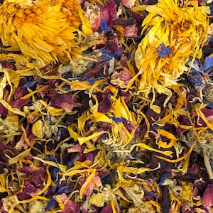 Puede incluir: Primer plano de una mezcla de hierbas y flores secas. La imagen presenta tonos vibrantes de amarillo, morado, azul y verde. La composici&oacute;n incluye cabezas de flores enteras y p&eacute;talos dispersos, creando una exhibici&oacute;n colorida y texturizada.