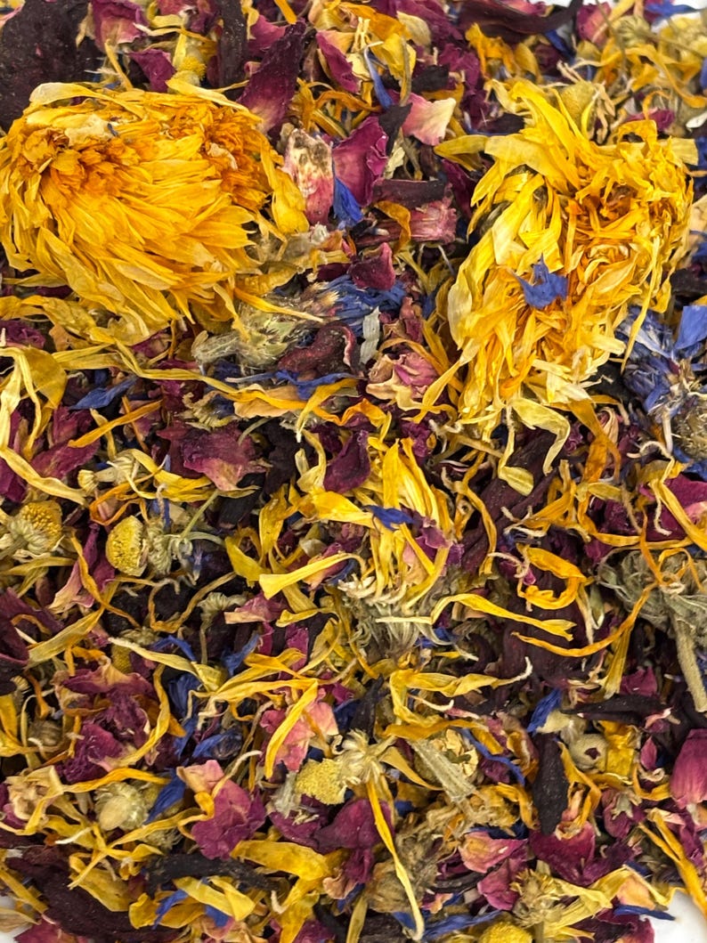 Puede incluir: Primer plano de una mezcla de hierbas y flores secas. La imagen presenta tonos vibrantes de amarillo, morado, azul y verde. La composici&oacute;n incluye cabezas de flores enteras y p&eacute;talos dispersos, creando una exhibici&oacute;n colorida y texturizada.