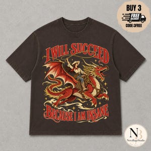 Puede incluir: Una camiseta de manga corta de color marrón oscuro con un gráfico de una persona con sombrero de vaquero montando un dragón rojo mientras sostiene un lazo. El texto "I WILL SUCCEED BECAUSE I AM INSANE" está impreso en rojo sobre el diseño.