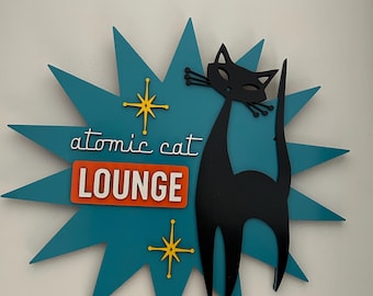 May include: A teal blue starburst with a black silhouette of a cat and the text "atomic cat LOUNGE" in white and orange letters.
