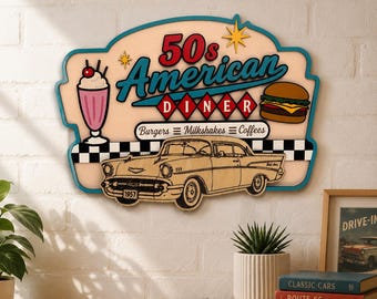 May include: A decorative wall sign featuring the text 50s American Diner, with illustrations of a milkshake, a hamburger, and a 1957 Chevrolet car. The sign has a cream background, a teal border, and a black and white checkered pattern at the bottom.